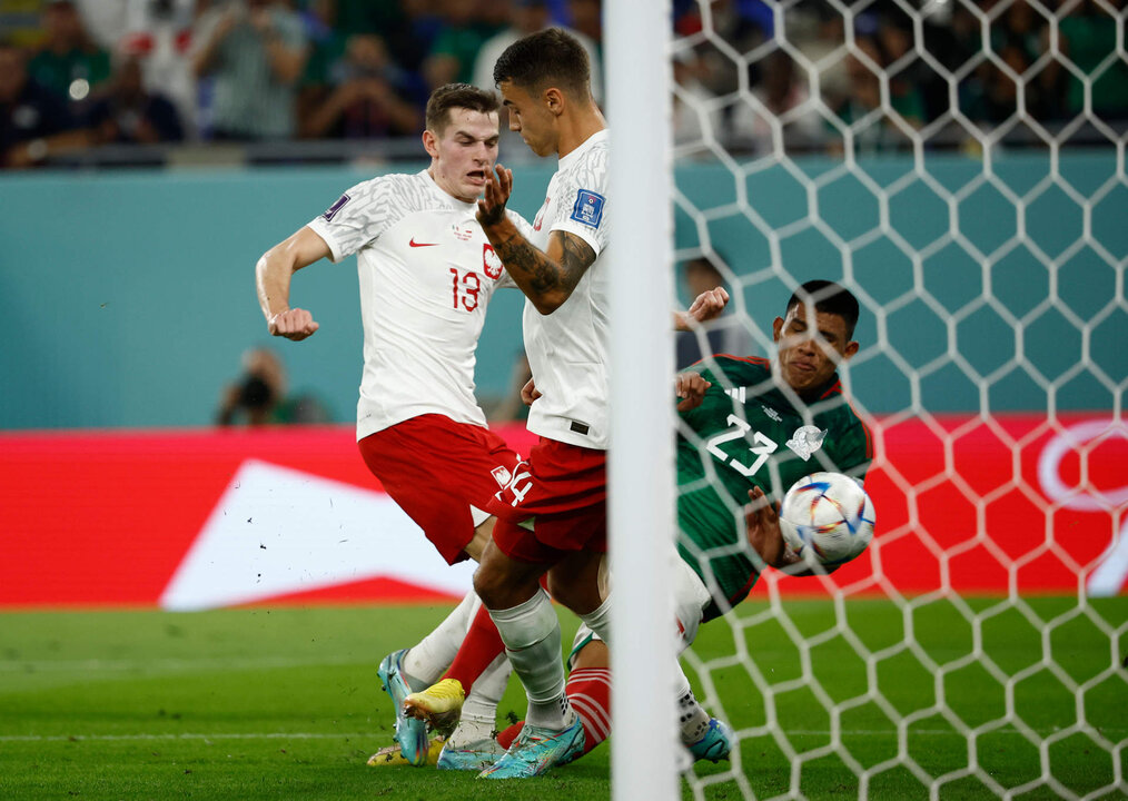 Jesús Gallardo (d) de México disputa un balón con Jakub Kaminski (i) y Jakub Kiwior de Polonia hoy, en un partido de la fase de grupos del Mundial de Fútbol Qatar 2022 entre México y Polonia en el Estadio 974 en Doha (Catar). EFE/ José Méndez