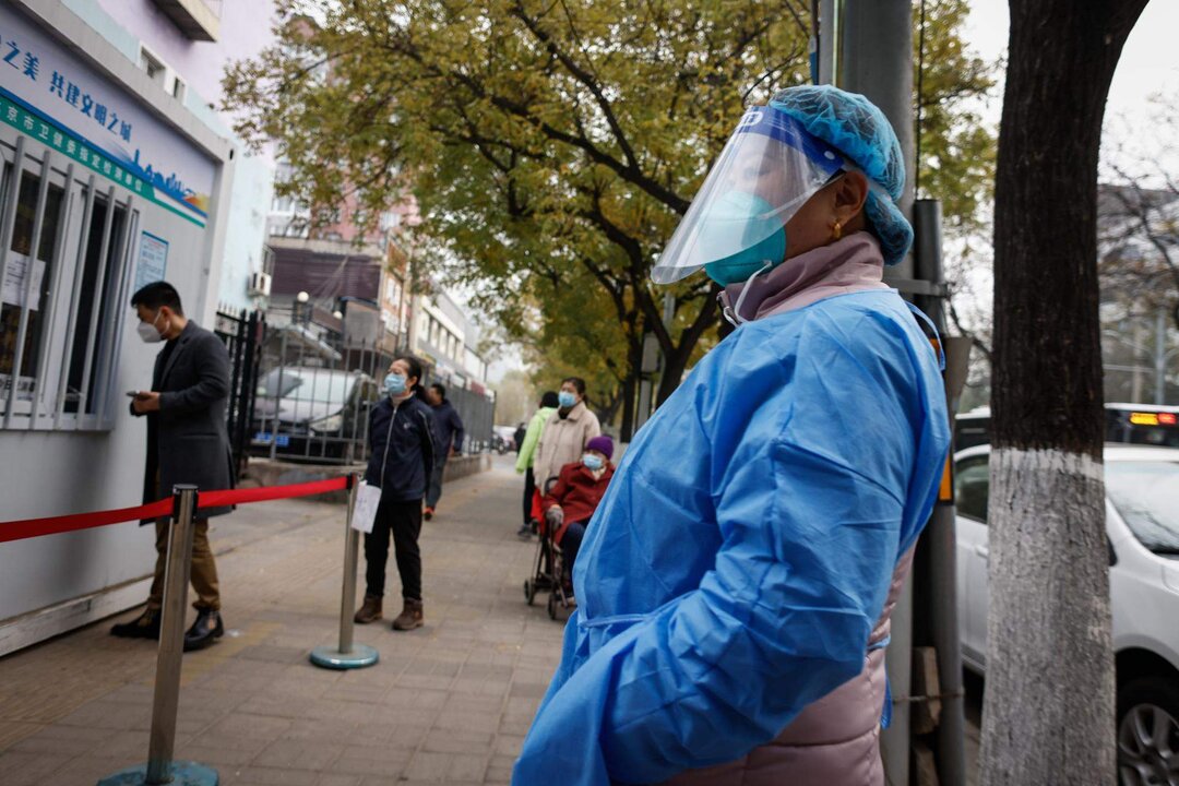 Ciudadanos hacen cola para someterse a pruebas para detectar el covid-19, en Shanghái. EFE/EPA/MARK R. CRISTINO