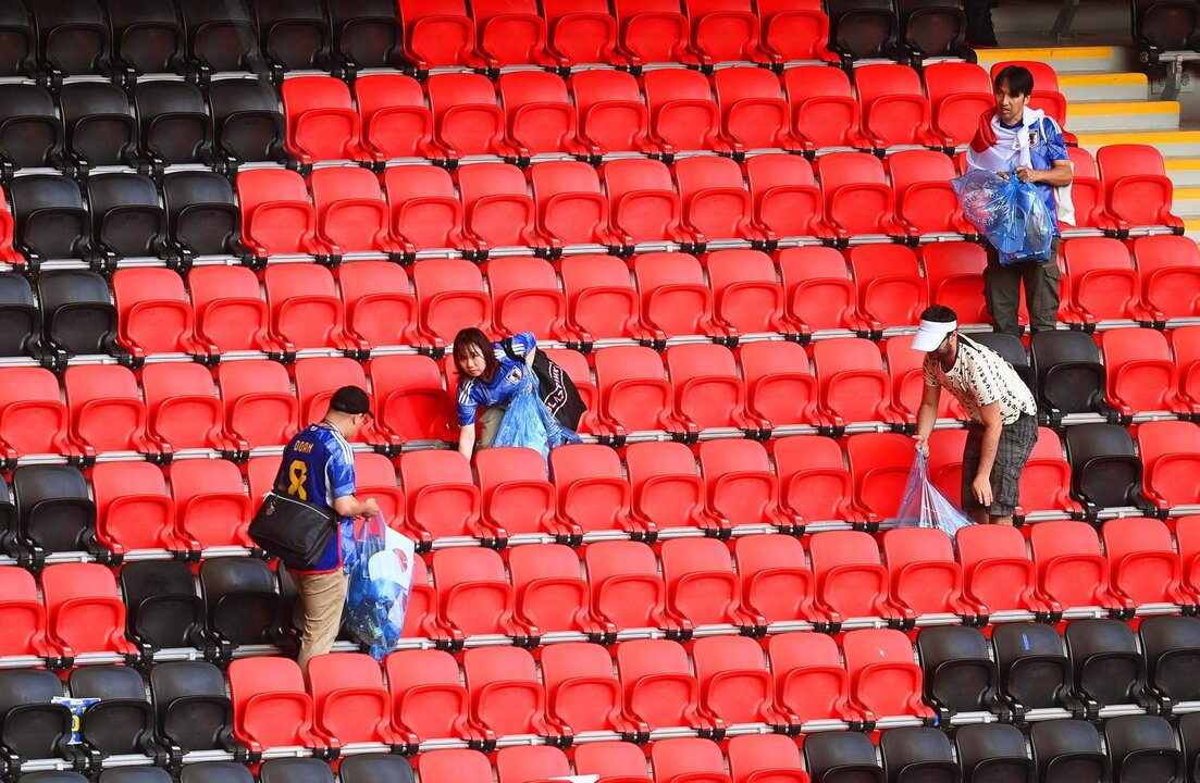 Los seguidores de Japón limpian las gradas en Estadio de Ali de cubo de Ahmad en Doha, Qatar, 27 noviembre 2022. EFE/EPA/Neil Sala