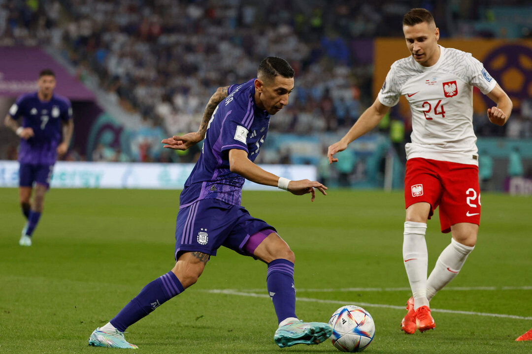 El argentino Ángel di María trata de regatear al polaco Przemyslaw Frankowski, en el partido de la tercera jornada de la fase de grupos disputado en el estadio 974 de Doha. EFE/JJ Guillén