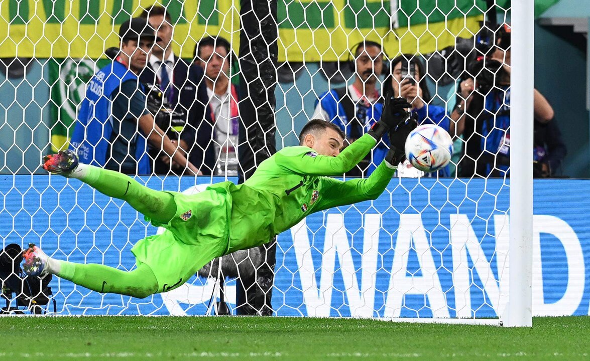 El guardameta croata Dominik Livakovic detiene el balón durante la tanda de penaltis del encuentro de cuartos de final ante Brasil. EFE/ Georgi Licovski